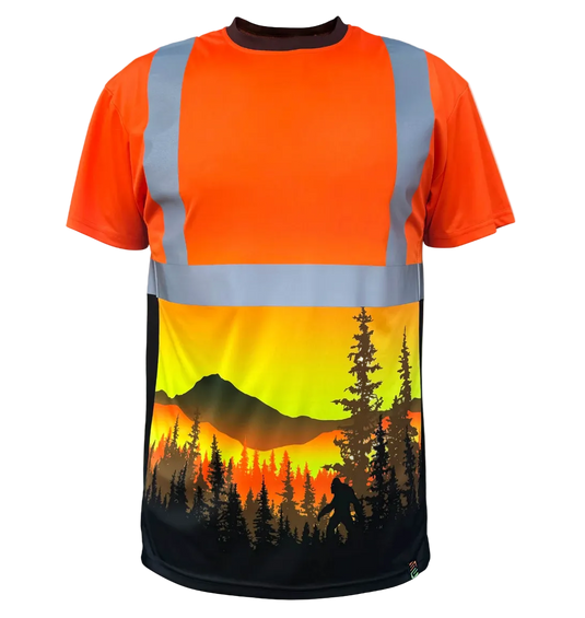 A short-sleeve high-visibility safety shirt with reflective silver-gray stripes on an orange body, featuring a large scenic graphic print of a mountain and pine forest sunset on the lower half.